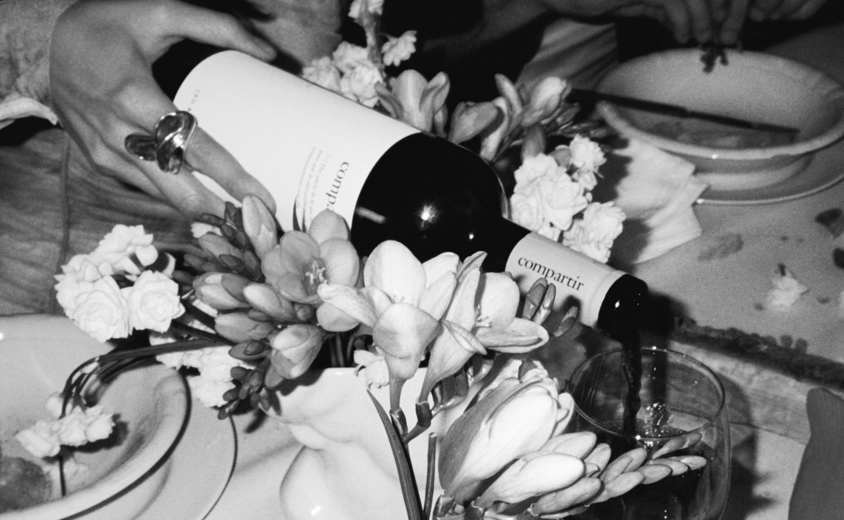 Vino tinto Compartir servido en una mesa con flores, fotografía en blanco y negro